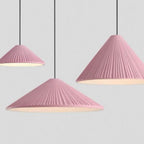 Three pendant lights with pleated, cone-shaped pink lampshades hang from black cords against a light gray background. Each Pendant Light features a ribbed texture and emits a soft white glow underneath.