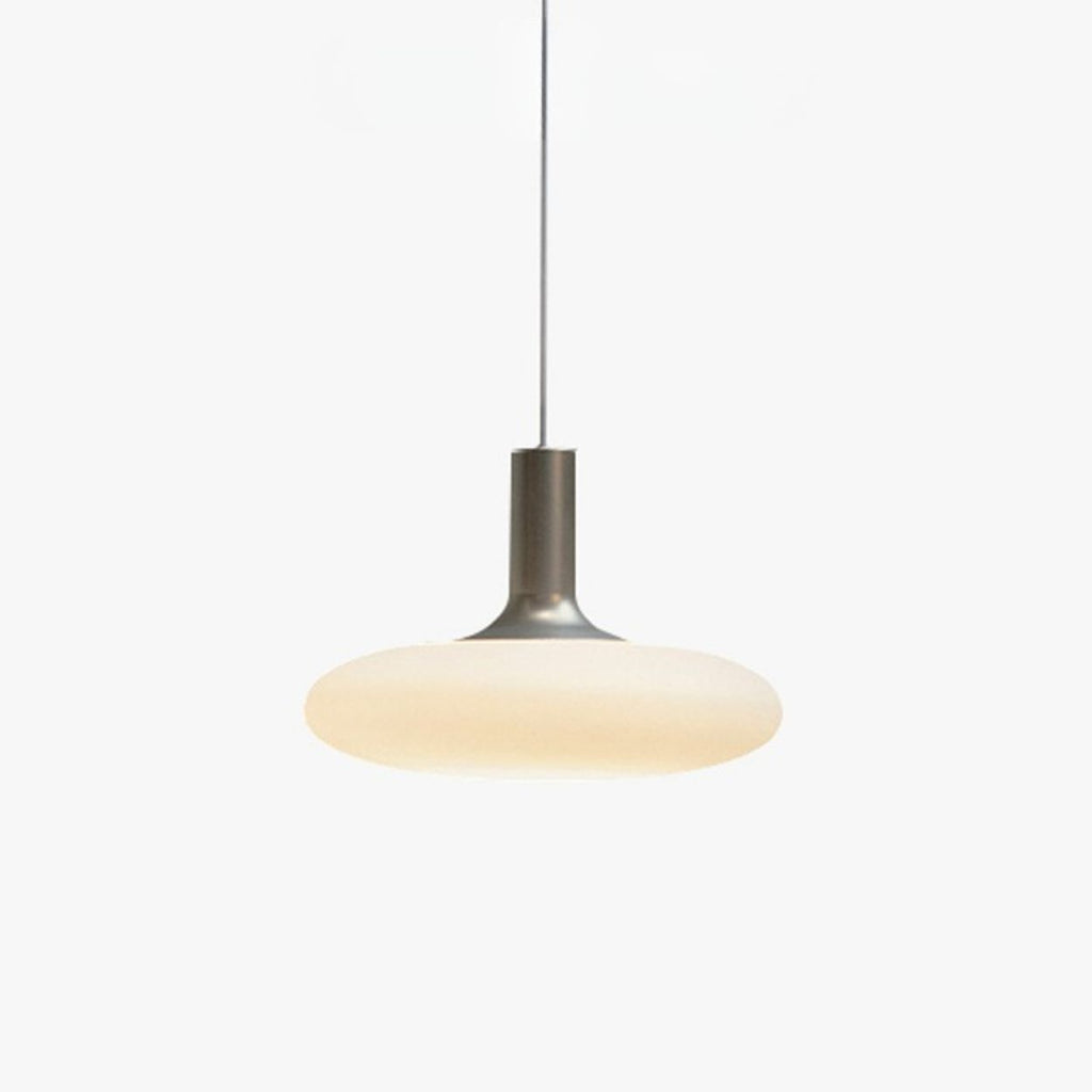A modern pendant light with a sleek metallic stem and a wide, flat, frosted glass shade emitting a soft warm glow, suspended from a thin black cord against a plain white background.