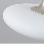 Close-up of a modern, white, dome-shaped pendant light with a metallic base, set against a plain gray background.