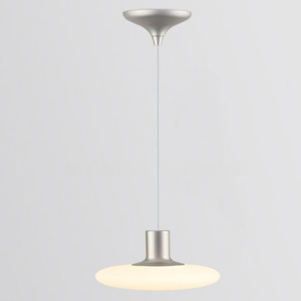 A modern pendant ceiling light with a silver fixture and a round, flat, frosted white shade hanging from a cord against a plain light gray background.