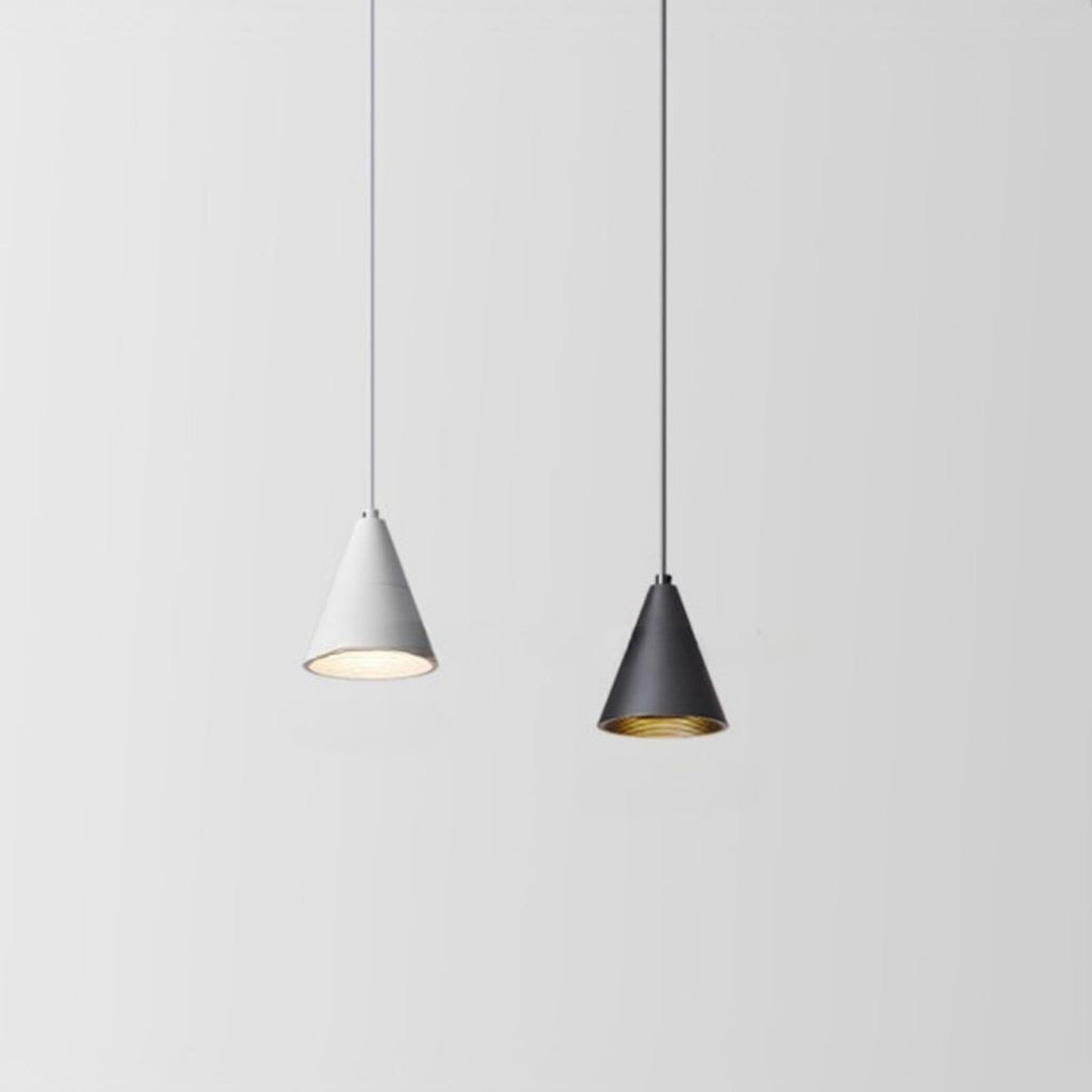 Two cone-shaped pendant lights hang from the ceiling against a plain light gray background; the left light is white and illuminated, while the right light is black and turned off.