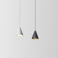 Two cone-shaped pendant lights hang from the ceiling against a plain light gray background; the left light is white and illuminated, while the right light is black and turned off.
