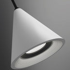 A modern, cone-shaped white pendant light hangs from a black cord against a gray background, featuring concentric ridges around the light source inside the shade. This Pendant Light adds contemporary flair to any space.