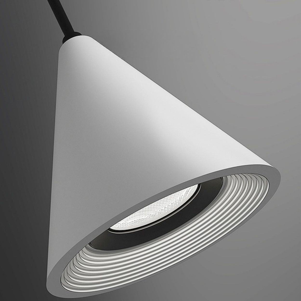 A modern, cone-shaped white pendant light hangs from a black cord against a gray background, featuring concentric ridges around the light source inside the shade. This Pendant Light adds contemporary flair to any space.
