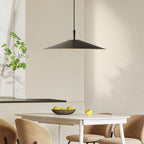 A modern dining room with a white table, beige chairs, and a striking pendant light hanging above. A bowl of green apples sits atop the table, while a plant on the windowsill enhances the minimalist, neutral design.