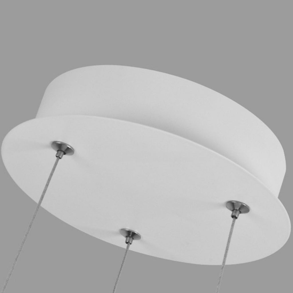 Close-up view of a modern round white pendant light mount with three metal cables attached to its underside, set against a plain gray background.