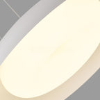 A close-up of a modern, minimalist ceiling light pendant with a smooth, oval-shaped white shade glowing softly against a gray background.