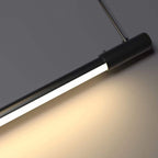 A close-up of a modern, wall-mounted black LED tube light that is turned on, casting a warm glow on a gray wall—perfect for those who appreciate the elegance of pendant light close ups.