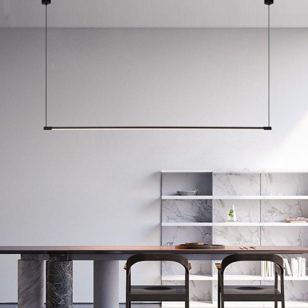Minimalist dining area with two chairs at a dark wooden table, marble pillar legs, open marble shelves on the back wall, and a sleek pendant light suspended from the ceiling.