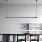 Minimalist dining area with two chairs at a dark wooden table, marble pillar legs, open marble shelves on the back wall, and a sleek pendant light suspended from the ceiling.