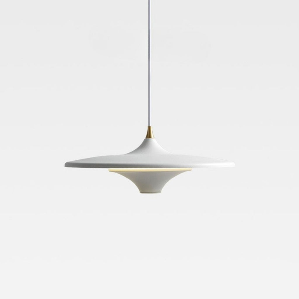 A modern, white pendant light with a smooth, disc-shaped design hangs from a thin cord against a plain, light gray background. Subtle gold accents can be seen at the top and around the middle.