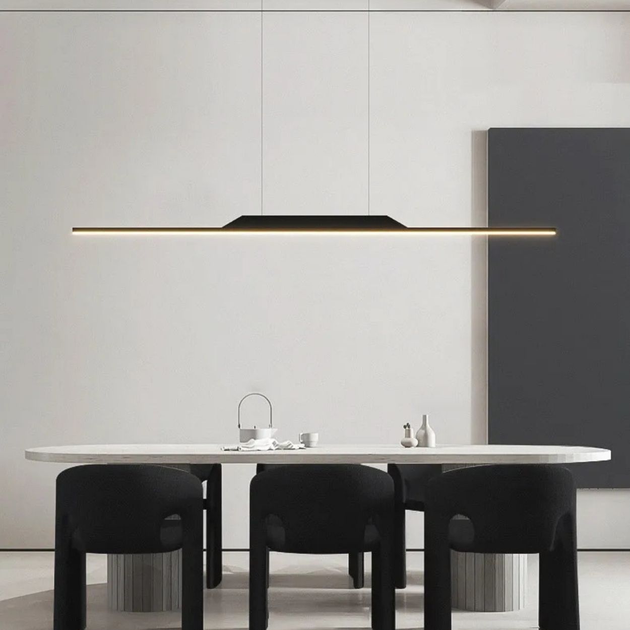 A modern dining room with a white table, four black chairs, and a striking pendant light above, featuring minimalist decor in neutral tones.