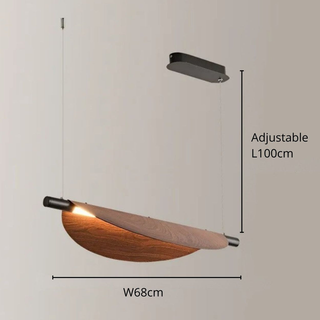 A modern chandelier pendant light with a curved wooden shade, suspended by two wires from a rectangular black ceiling mount. The shade is 68cm wide and height adjustable up to 100cm. The light emits a warm glow.
