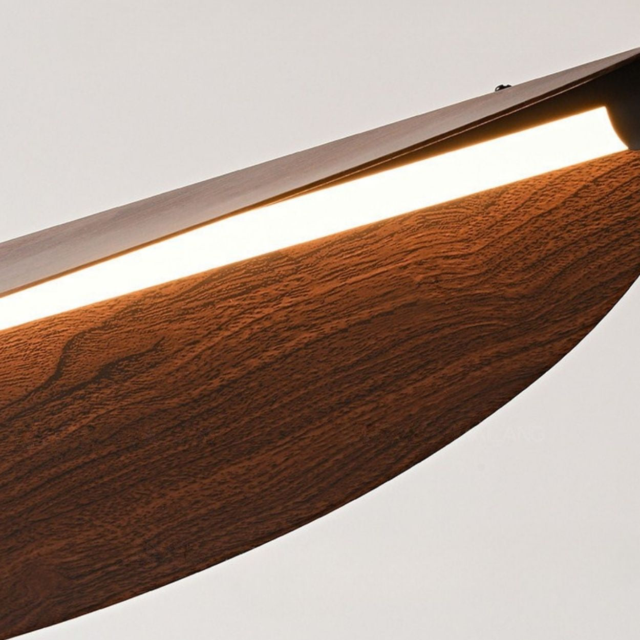 Chandelier close up of a modern light fixture with a wooden finish, featuring a slim, curved design and a built-in LED strip emitting warm white light against a neutral background.