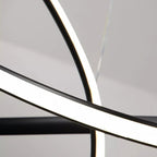A close-up view of intersecting curved LED light strips against a neutral background, creating an abstract, modern pendant light close up with bright white illumination.