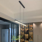 A modern dining area features a sleek pendant light hanging from the ceiling, glass sliding doors on the left, a refrigerator, and a backlit shelving unit displaying various bottles and decor items.